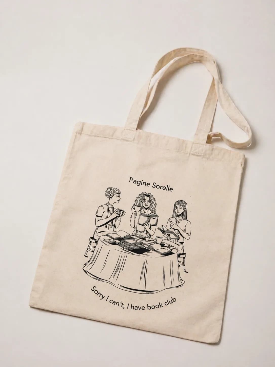 Tote bag in cotone naturale con tre lettrici disegnate attorno a un tavolo di libri e la scritta «Sorry I can’t, I have book club»